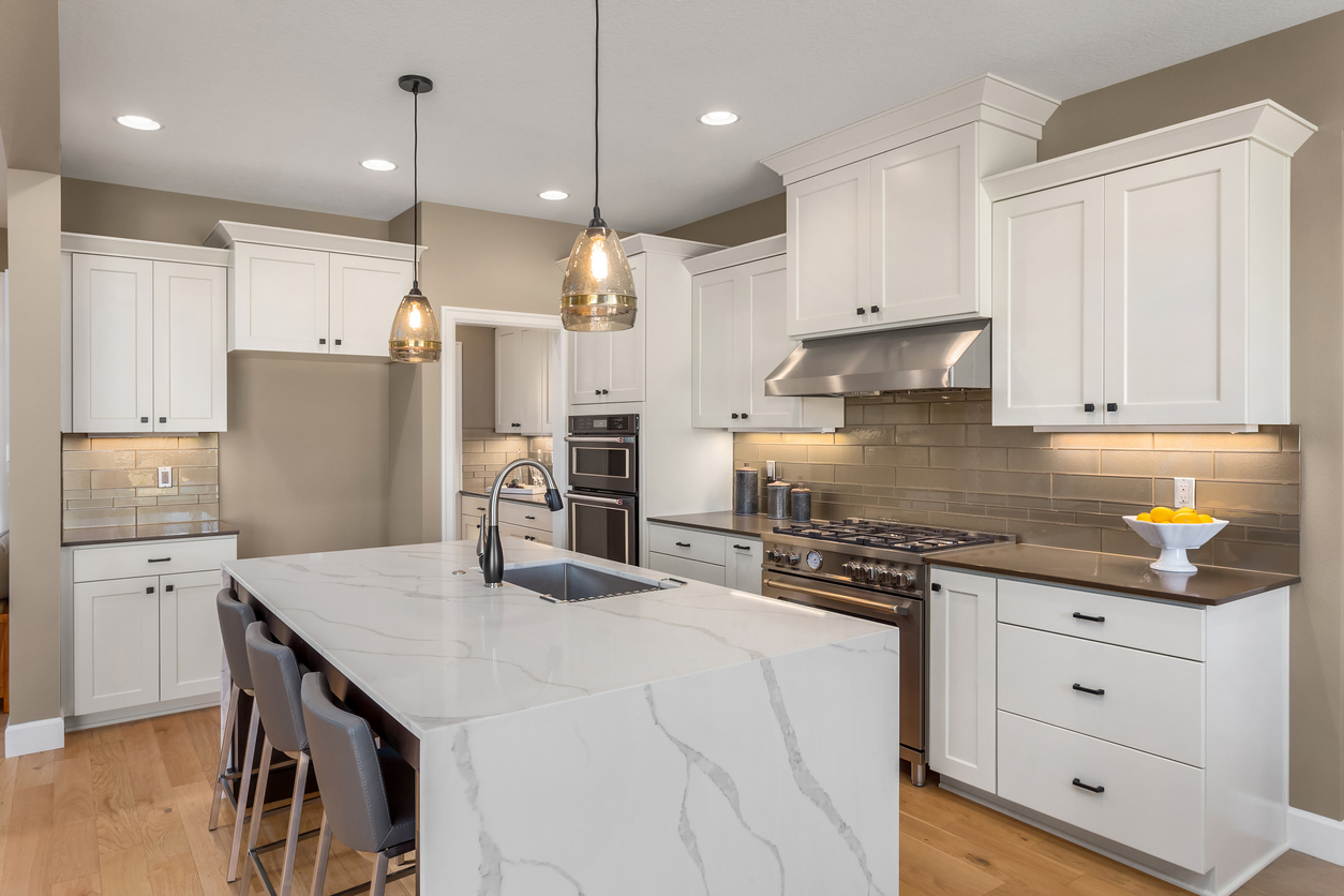 beautiful kitchen in new home with island, pendant lights, and hardwood floors. Cabinet Corner